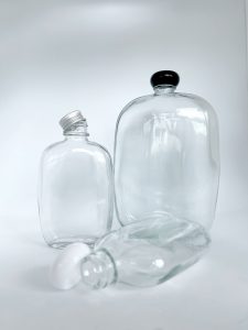 round fat clear glass bottle with aluminum and plastic cap